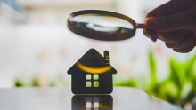 Magnifying glass hovering over model house